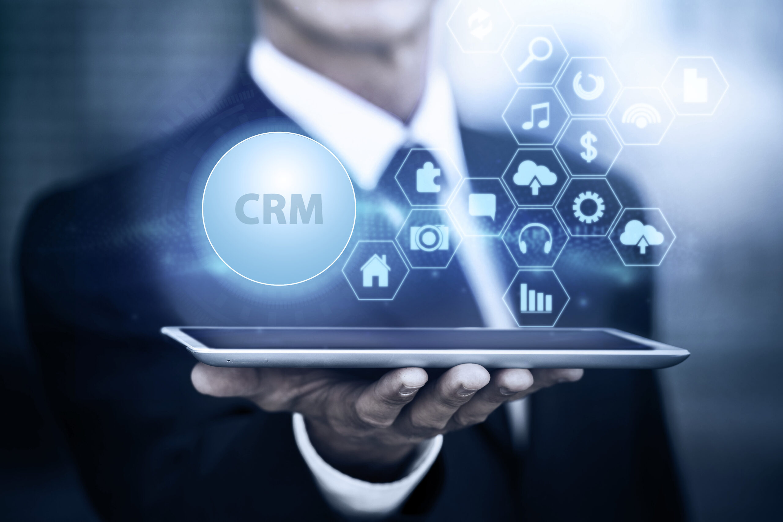 **Alt Text:** Business professional using a tablet with a CRM dashboard and automation icons, representing CRM automation workflows that improve sales, customer management, and business efficiency for SMEs.